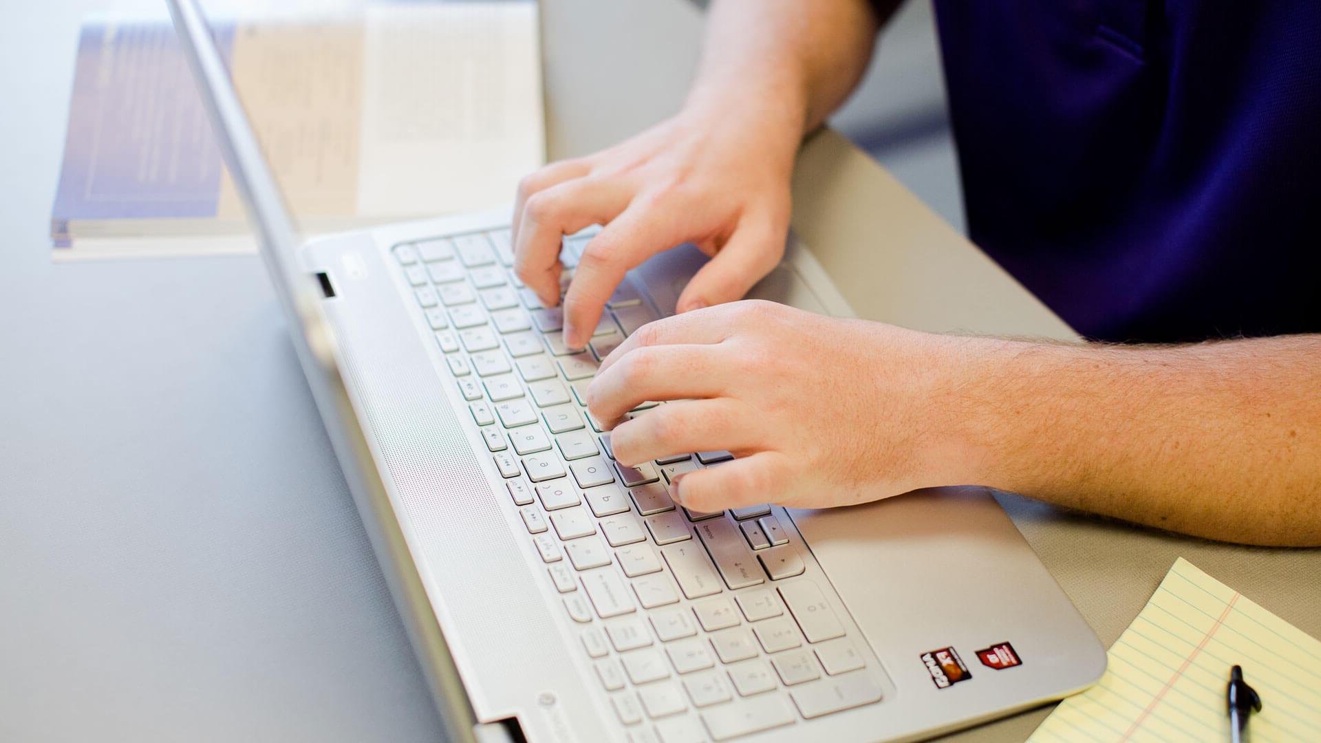 hands typing on laptop